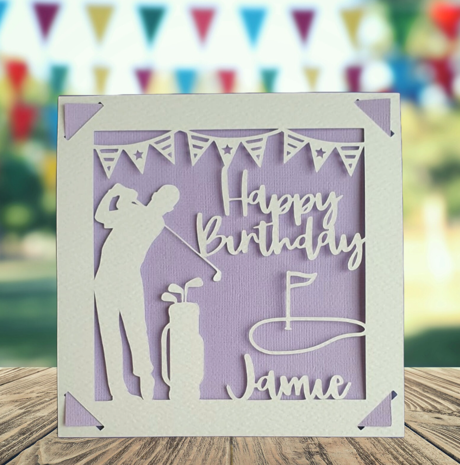 A personalised golfing birthday card for someone who loves golf. The card is fully customisable with the recipient's name. The card features a figure playing golf, with their golf club, bag and a cut out of a golf hole with flag. The background colour is purple.