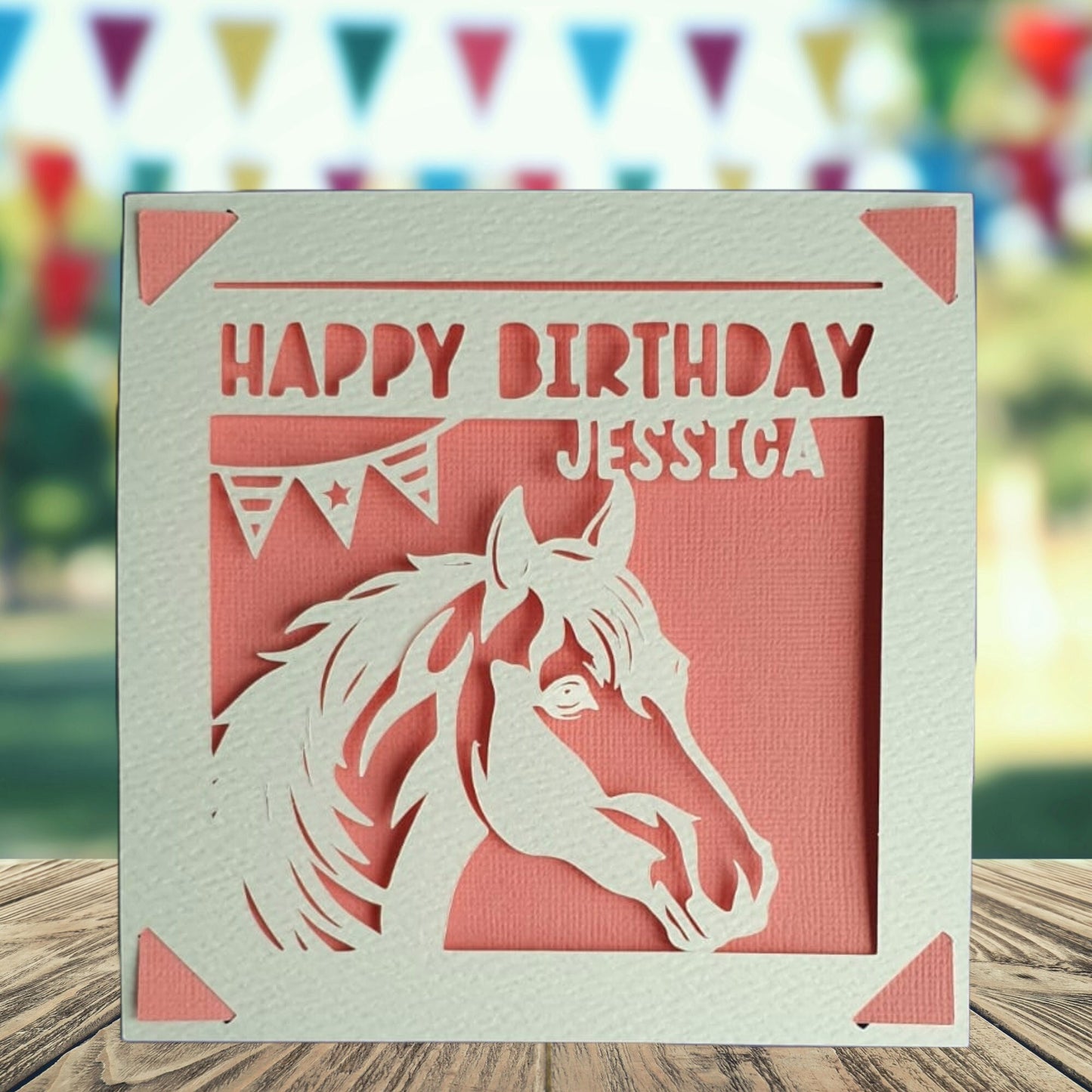 A personalised birthday card with a horse silhouette, made from hammered white card, with the text 'Happy Birthday' and a space to add a name and age if required. The background is pink.