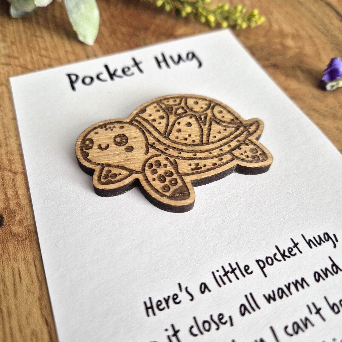 Tortoise hug token with a gift message attached to the back.