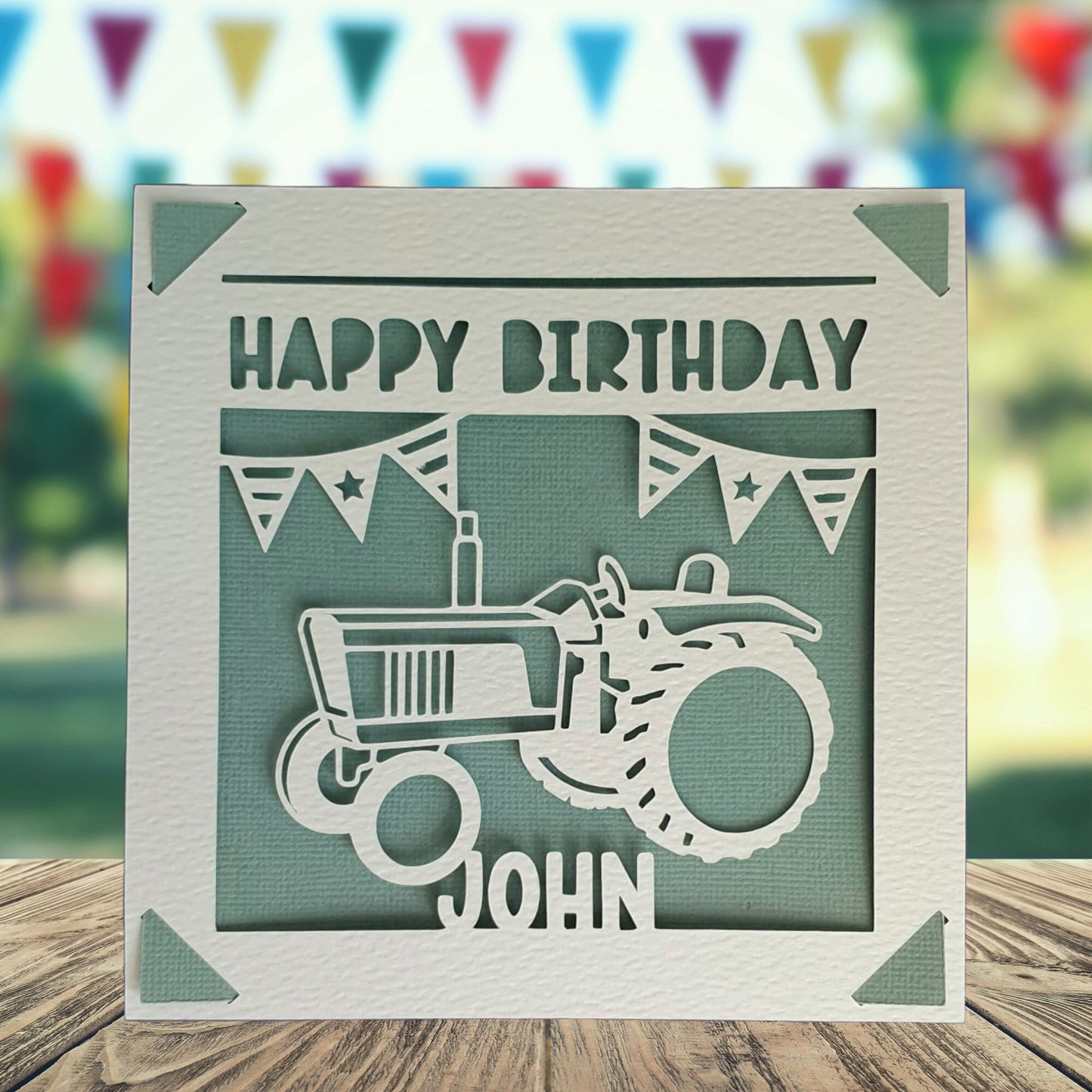 A personalised greeting birthday card with a tractor on the front. Text saying 'happy birthday' with the space to add a name and age. Card background is a teal colour.