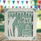 A personalised golfing birthday card for someone who loves golf. The card is fully customisable with the recipient's name. The card features a figure playing golf, with their golf club, bag and a cut out of a golf hole with flag. The background colour is teal.