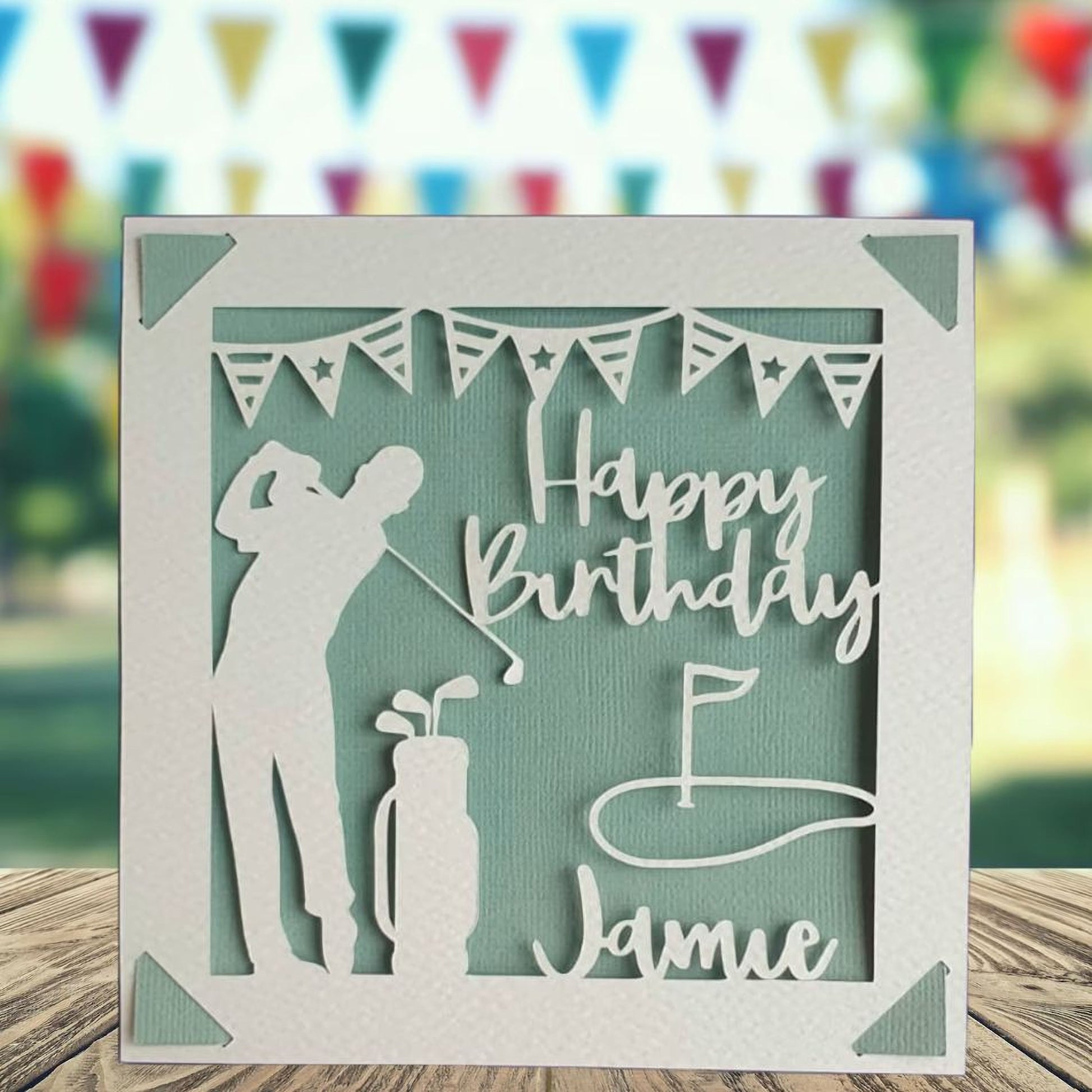 A personalised golfing birthday card for someone who loves golf. The card is fully customisable with the recipient's name. The card features a figure playing golf, with their golf club, bag and a cut out of a golf hole with flag. The background colour is teal.