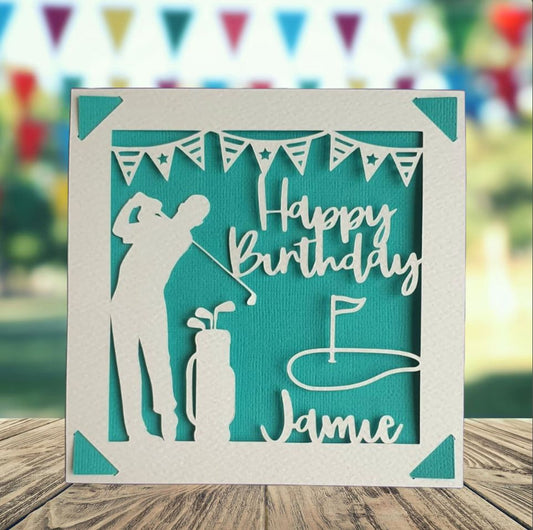 A personalised golfing birthday card for someone who loves golf. The card is fully customisable with the recipient's name. The card features a figure playing golf, with their golf club, bag and a cut out of a golf hole with flag. The background colour is turquoise.