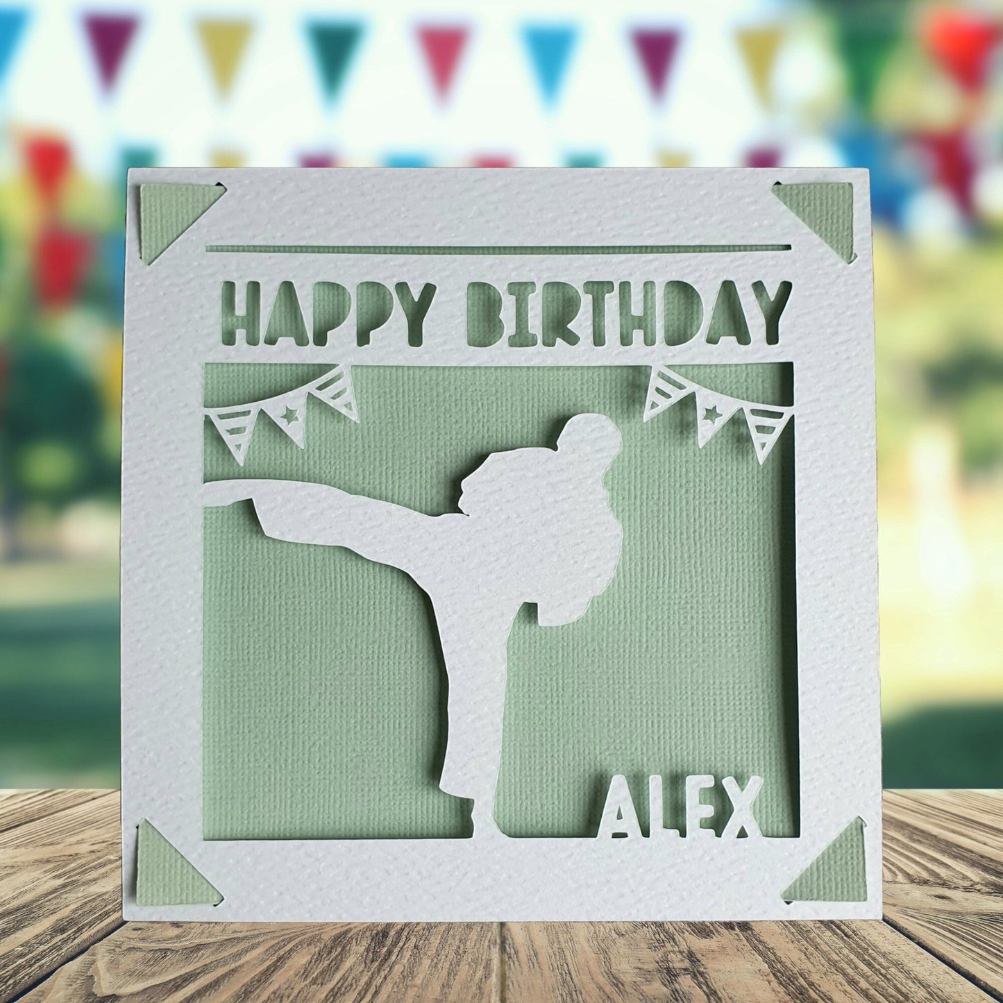 A personalised birthday card featuring a cut out of a karate and martial arts silhouette, with the text 'Happy Birthday' and a space to add a name and age if required. The card is light green in the background.